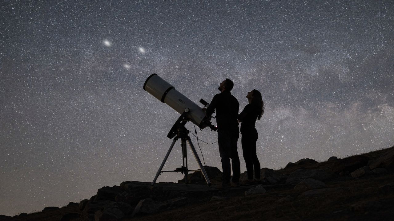 Couple observing the night sky with telescope pointing toward the Leo Triplet - ASTRONOMIKA TV